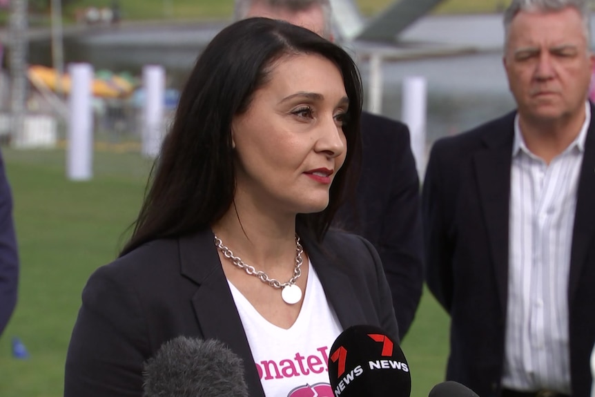 A woman wearing a DonateLife t-shirt in a press conference