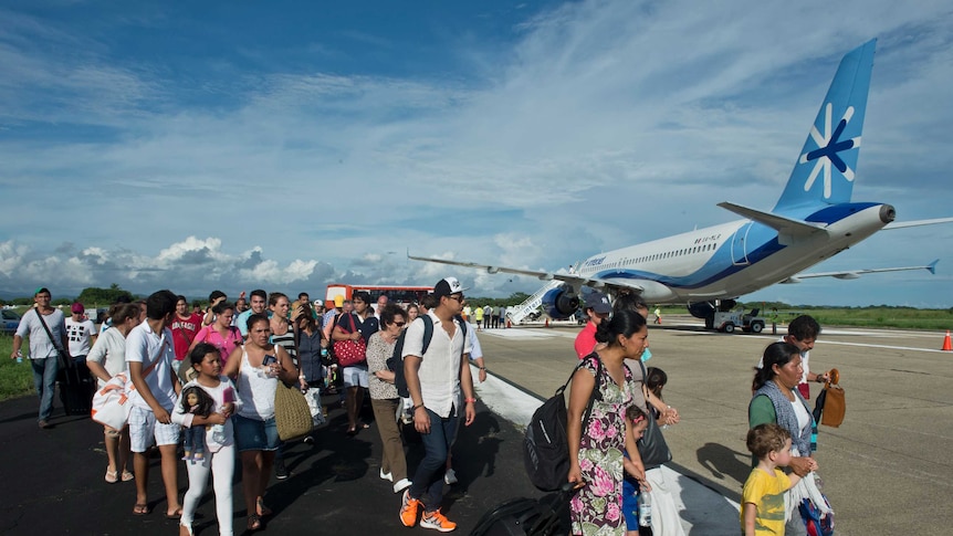 Tourists walk at Acapulco airport after the city was flooded by heavy rains.