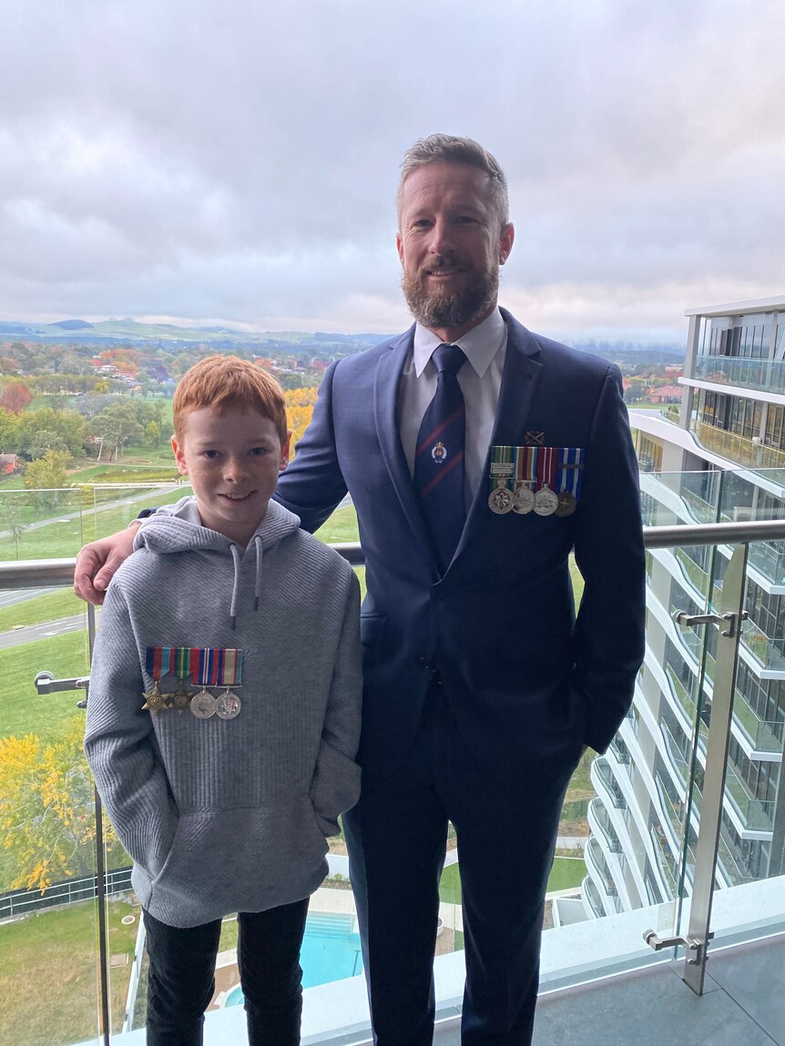 A father and son both wearing military service medals