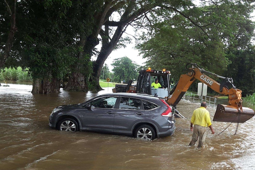 A car sits in floodwaters at Foxton Bridge north of Mossman.