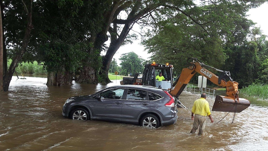 A car sits in floodwaters at Foxton Bridge north of Mossman.