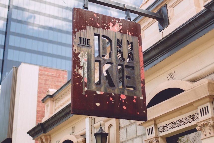 A rusty sign saying The DUKE on a 19th century pub