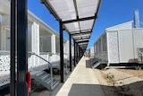 An outdoor walkway near cabins designed for quarantine