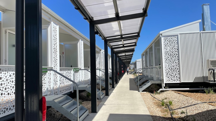 An outdoor walkway near cabins designed for quarantine