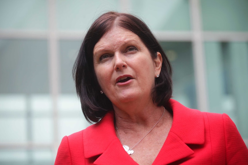 A woman in a red jacket with dark hair