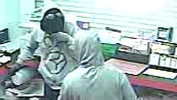 Security camera vision of two people during an attempted robbery at a Burnie shop.