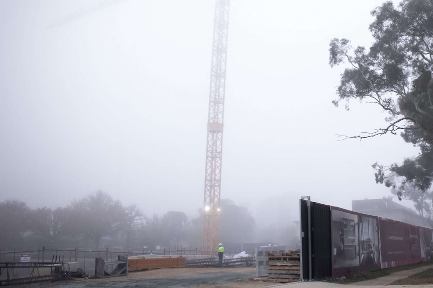 A construction site in Canberra, shrouded in fog