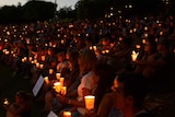 People take part in a candlelight vigil in support of asylum seekers in Brisbane.