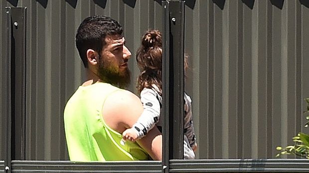 Mehmet Biber in a backyard holding a child.