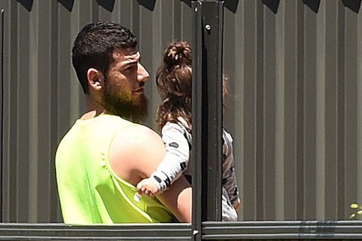 Mehmet Biber in a backyard holding a child.