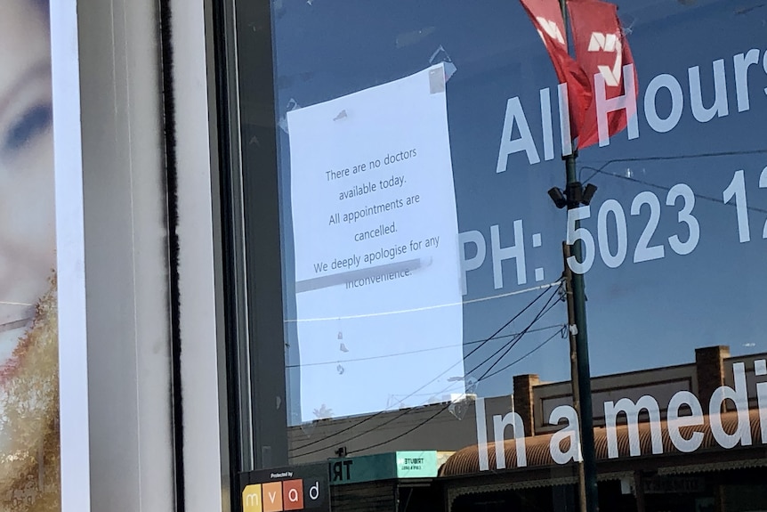 A piece of paper with text on it stuck to a glass door.