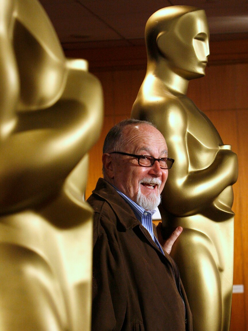 Oscar producer Gil Cates poses with golden statues
