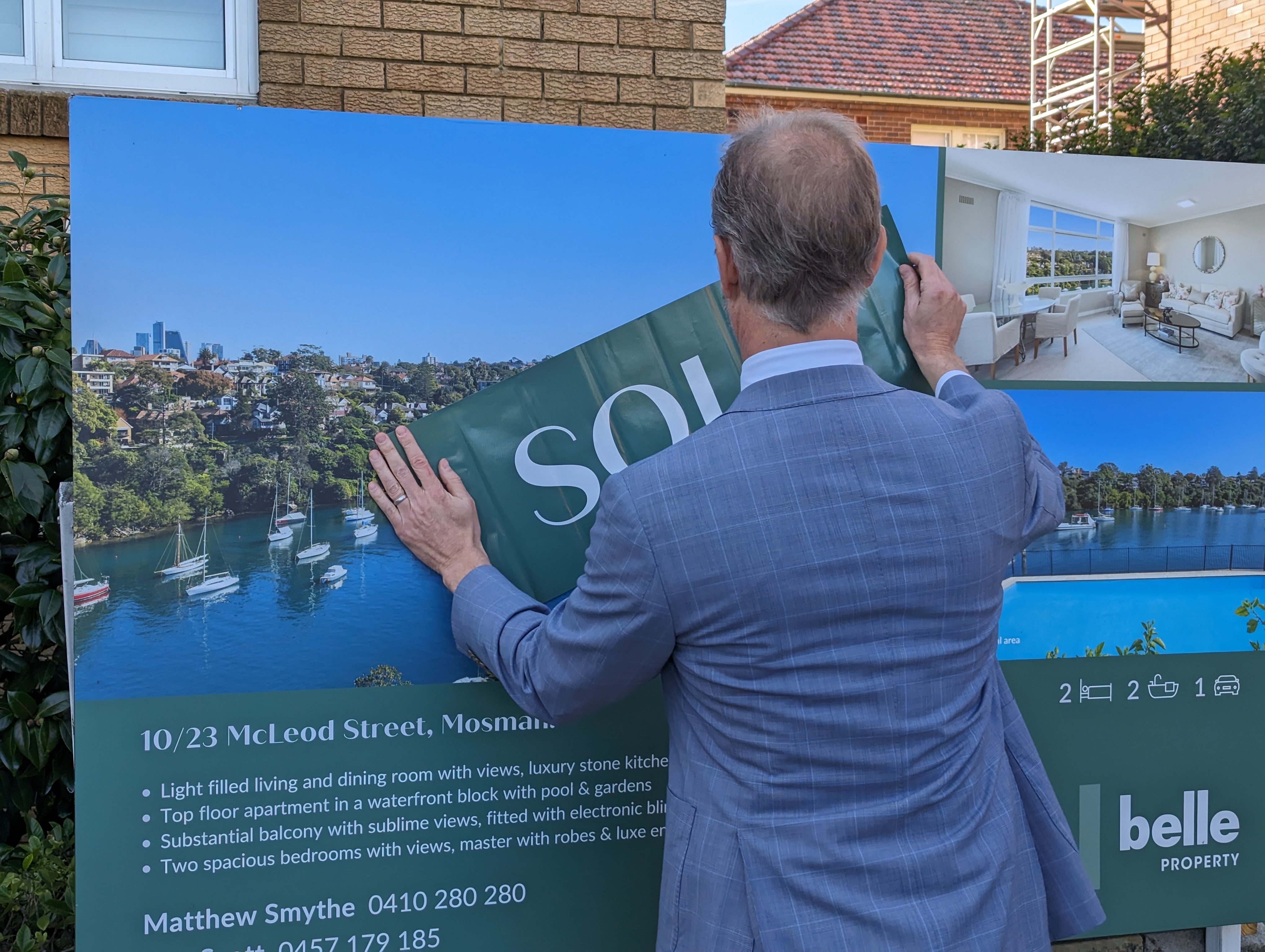 Real estate agent puts up a sold sticker after this Mosman apartment sold at auction.
