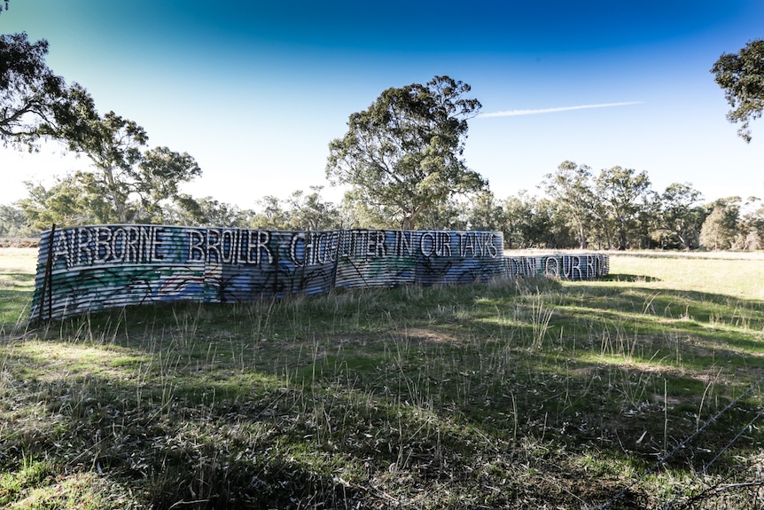 words written in big letters on a 10 metre length of roofing style metal sign in a field