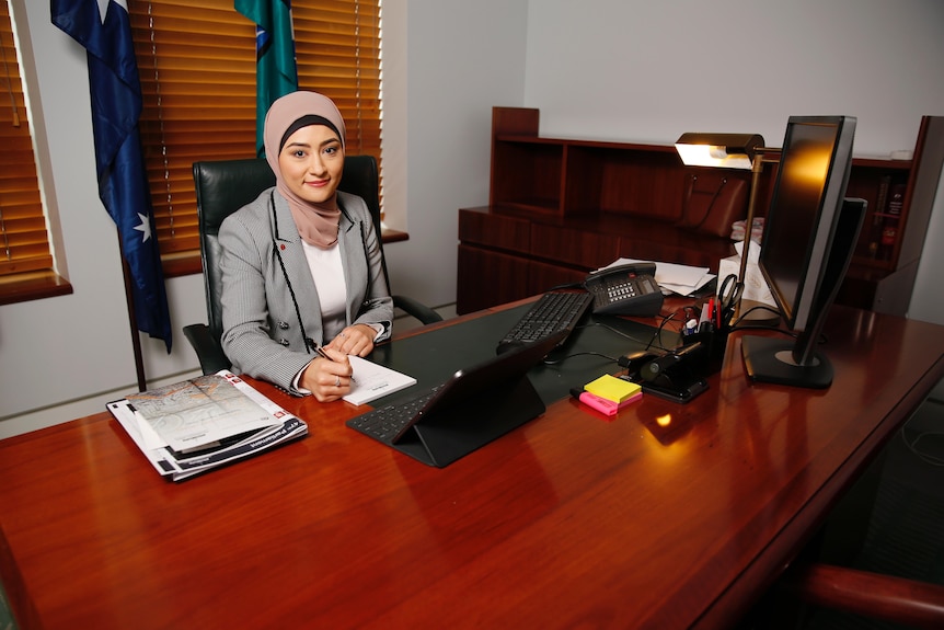 Fatima Payman sits at a desk in her Parliament House office