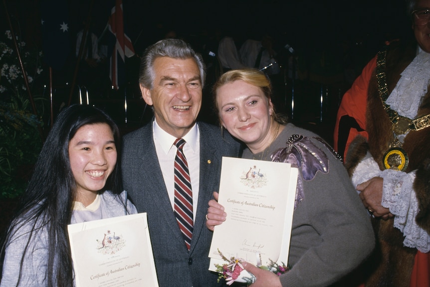 Bob Hawke with two women, holding certificates