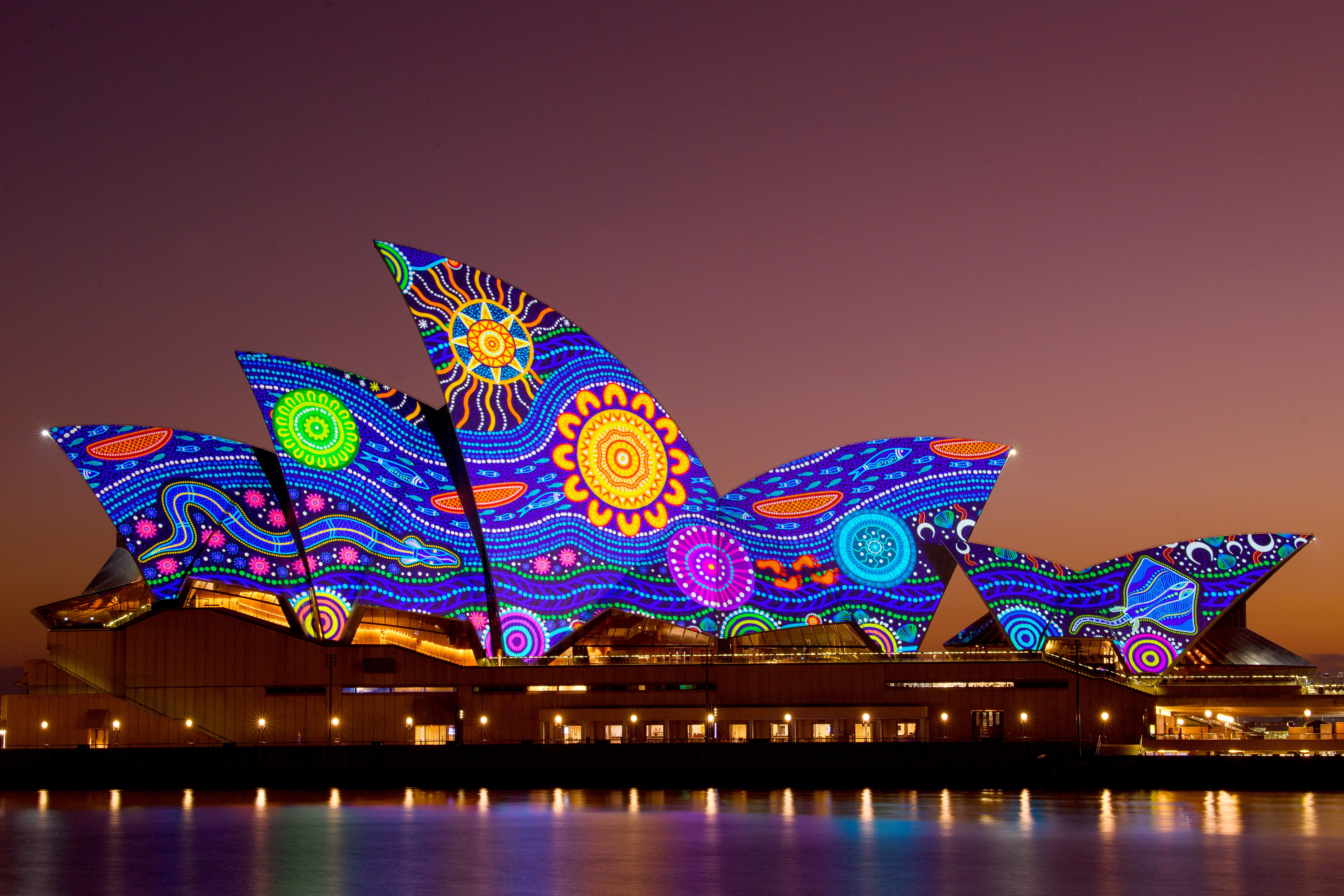 The Sydney Opera House is lit up in an Aboriginal artistic design.