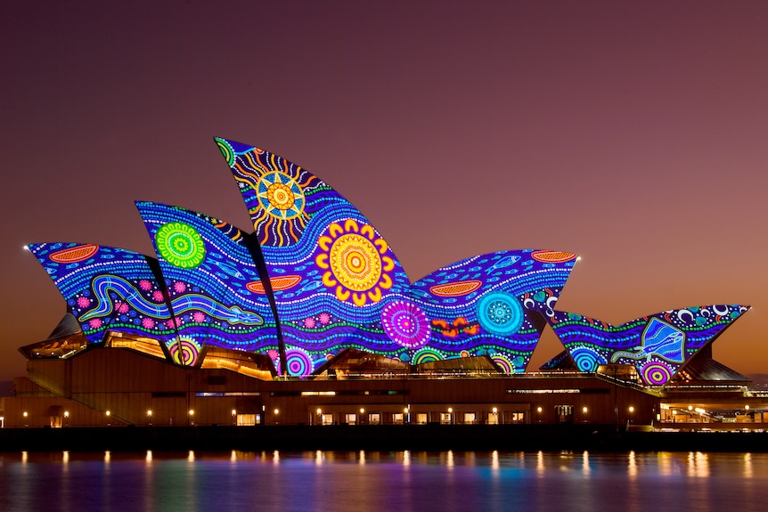 The Sydney Opera House is lit up in an Aboriginal artistic design.