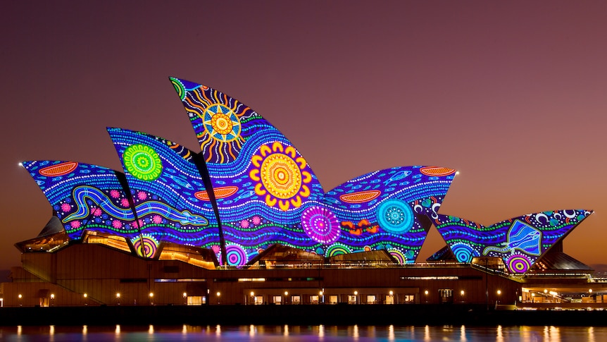The Sydney Opera House is lit up in an Aboriginal artistic design.