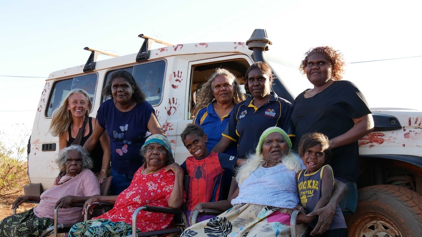 Women from the Kapululangu Aboriginal Women's Law and Culture Centre stand with the women they care for.