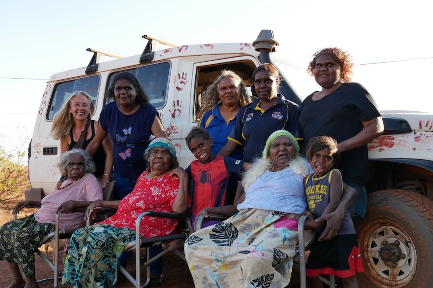 Women from the Kapululangu Aboriginal Women's Law and Culture Centre stand with the women they care for.