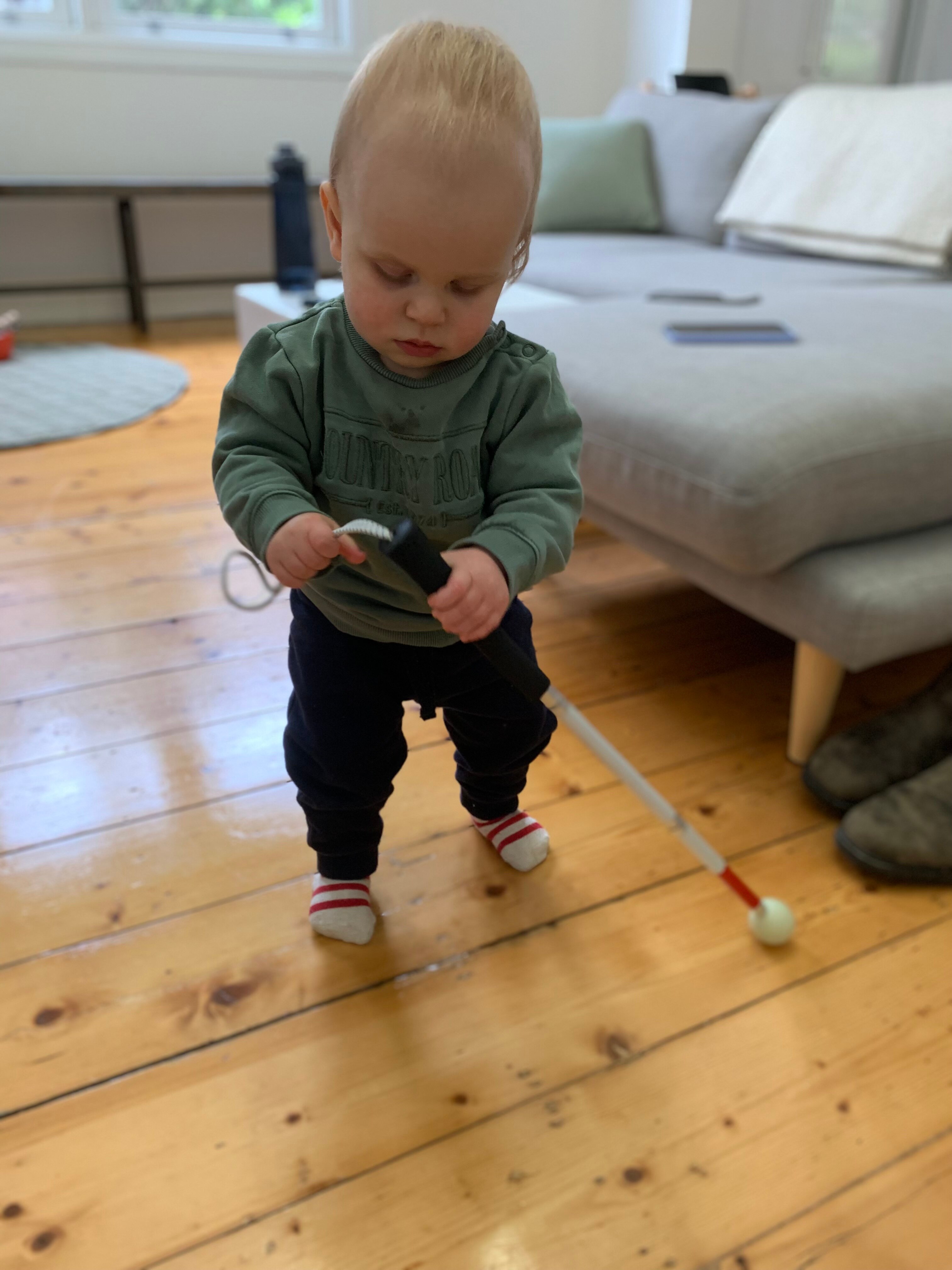 A young boy holding a cane