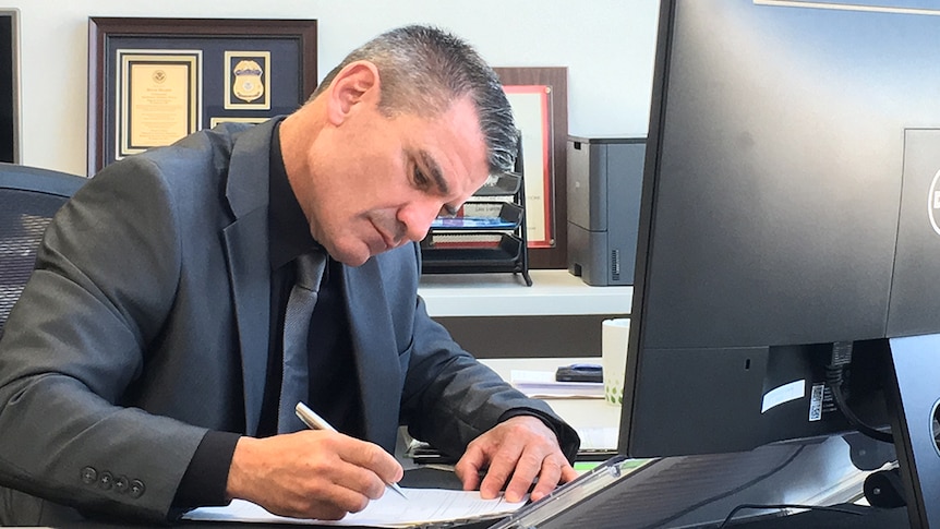 New ASADA boss David Sharpe looks down and writes in his office.