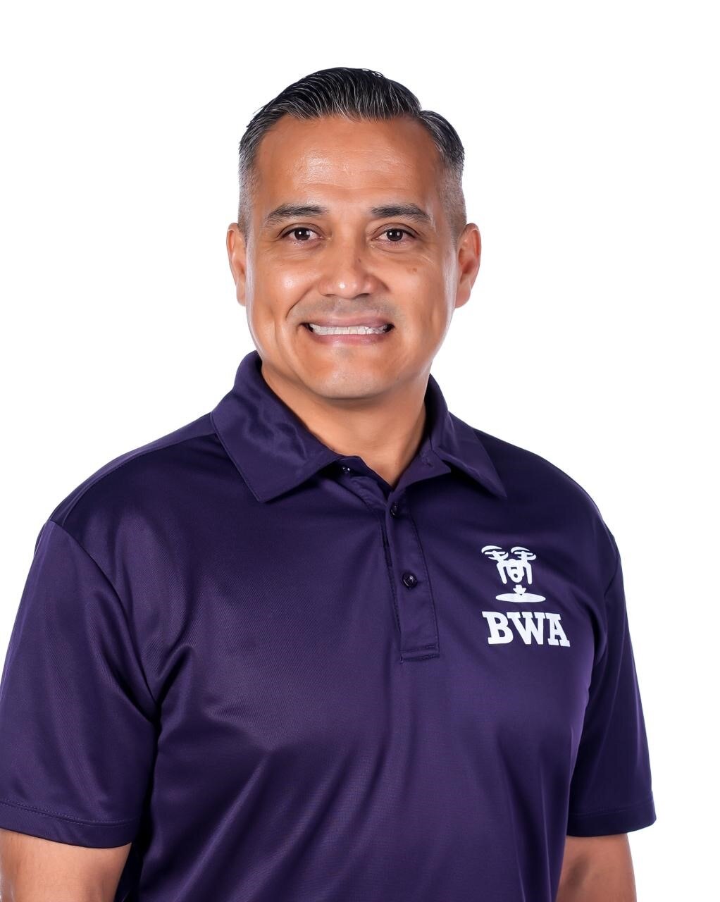 A Guam man smiling in a dark purple collared tee shirt
