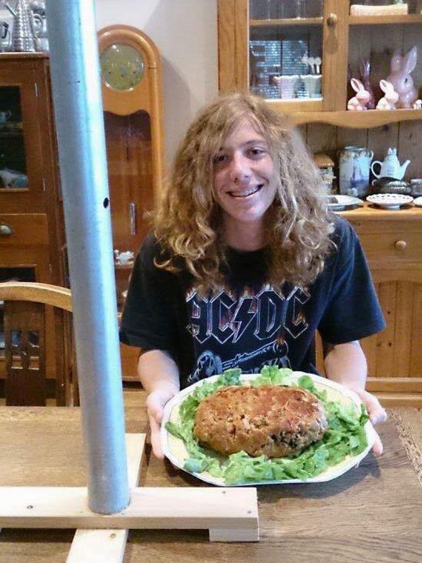 Jack Burrows holding plate of meatloaf on lettuce with Festivus pole in foreground.