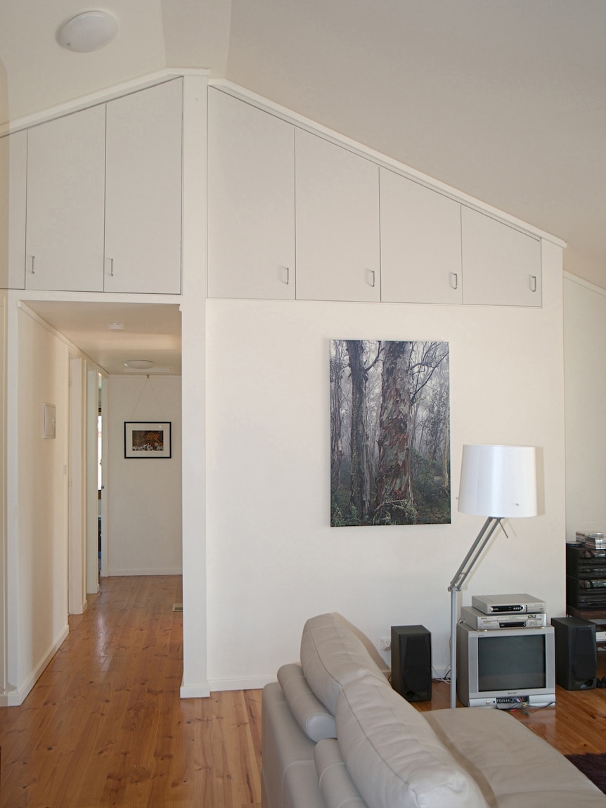 An interior shot of a lounge room in an ex-govie house featuring floor boards, high ceilings and roof storage.