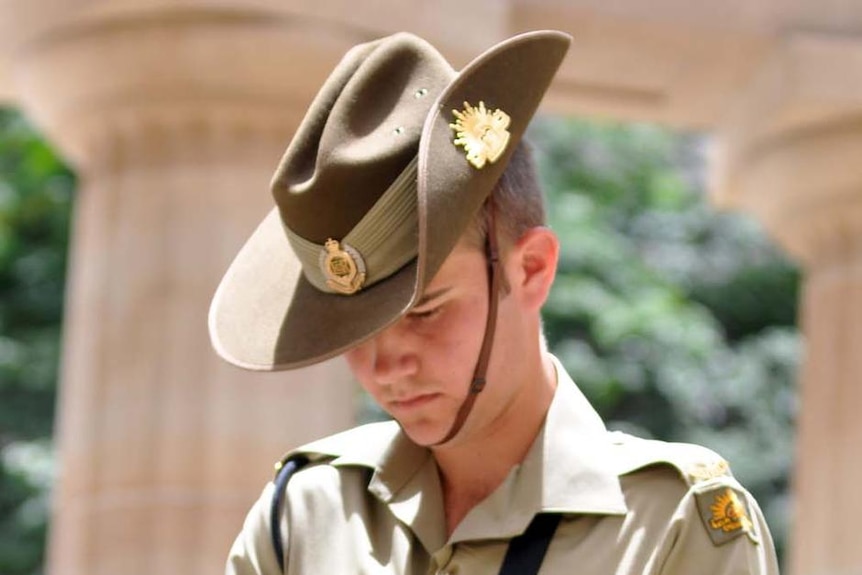 A soldier bows his head