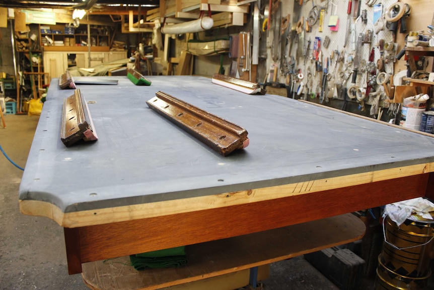 The slate top of a pool table Mr Standage is working on