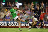 Ireland player kicking the ball over Jack Trengove of Australia in International Rules