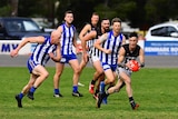 Men running around on an oval with a football in one man's hands.