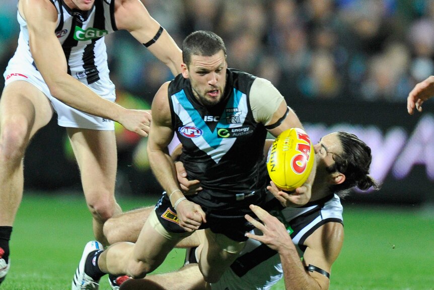 Intriguing encounter ...The Power's Travis Boak is tackled by Brodie Grundy