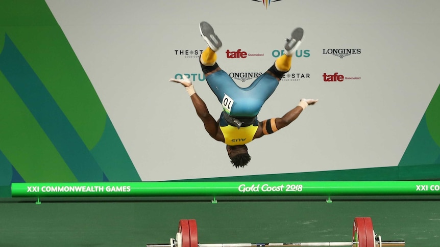Australian weightlifter backflips after completing a successful snatch.