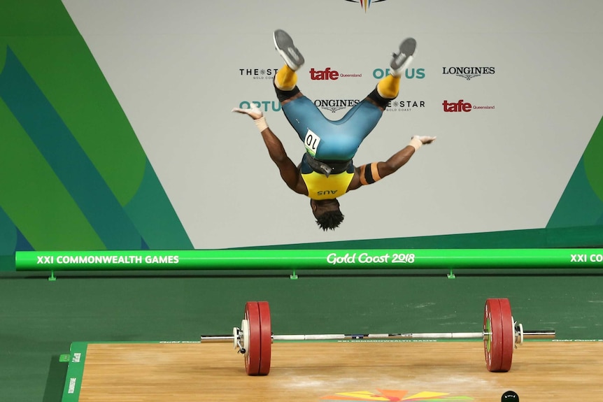 Australian weightlifter backflips after completing a successful snatch.