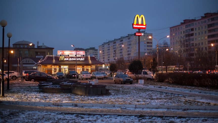 A McDonalds store is lit up at night surrounded by snow in Russia.