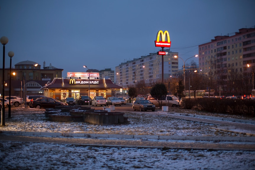 A McDonalds store is lit up at night surrounded by snow in Russia.
