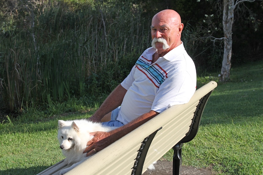 John Warren rests on a park bench with his dog