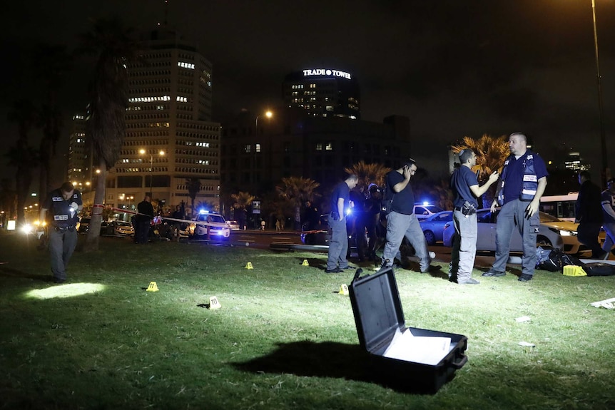 Israeli police officers look for evidences near the scene of the stabbing attack.