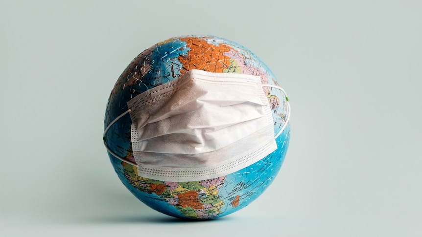 A globe made of jigsaw pieces wrapped with a white surgical mask
