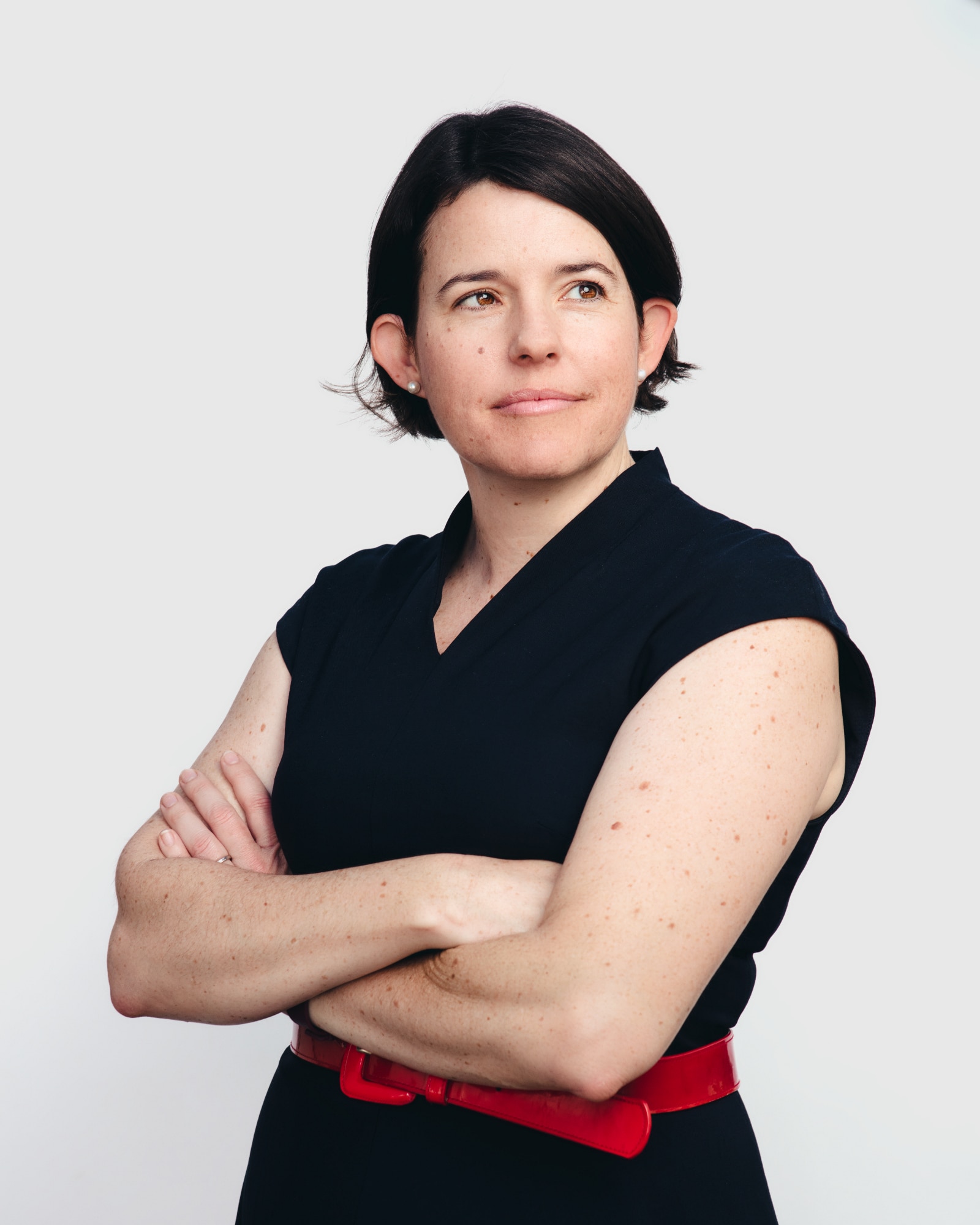 una mujer, probablemente de unos 40 años, con cabello castaño corto y una camisa negra, mirando hacia la derecha