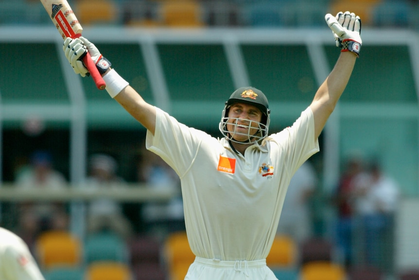 Matthew Hayden holds both arms in the air
