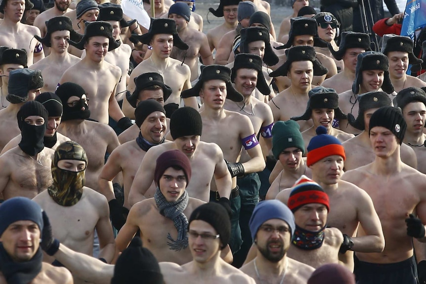Half-naked participants run in the Real Men's Race during Defenders of the Fatherland Day