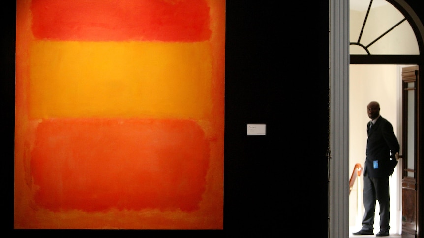 A security guard stands at a gallery entrace where Mark Rothko's Orange, Red, Yellow is hung.