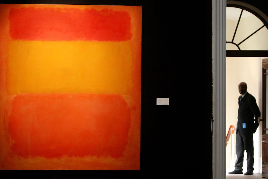 A security guard stands at a gallery entrace where Mark Rothko's Orange, Red, Yellow is hung.