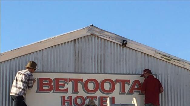 Robert's son JT Haken and friends restoring the Betoota Hotel's old sign.