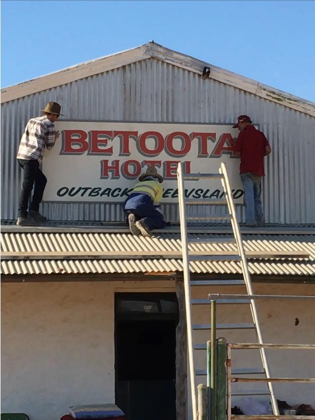 Robert's son JT Haken and friends restoring the Betoota Hotel's old sign.