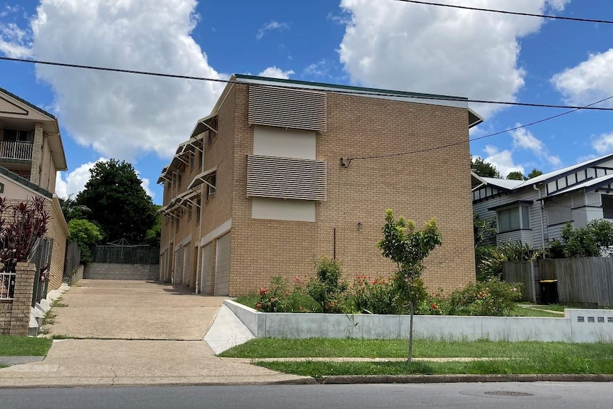 A yellow-brick apartment complex in suburban Brisbane